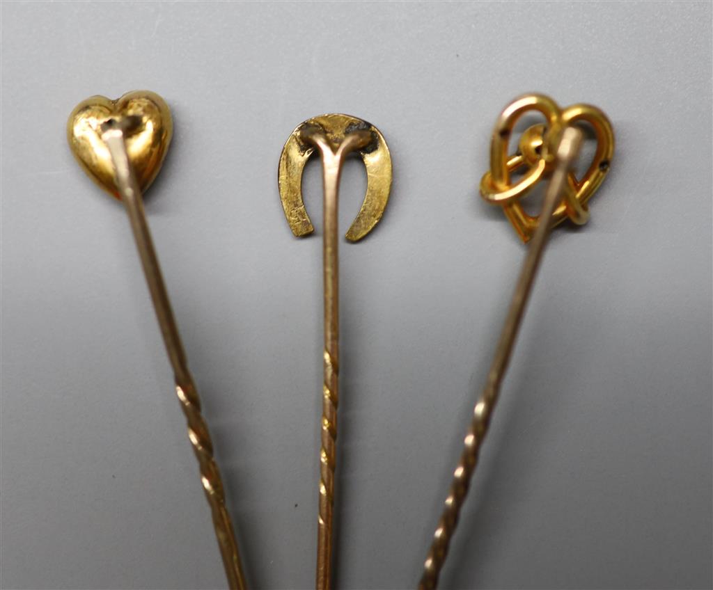 Three assorted Edwardian yellow metal stick pins, one set with diamond chip, 59mm et infra, gross 3.2 grams.